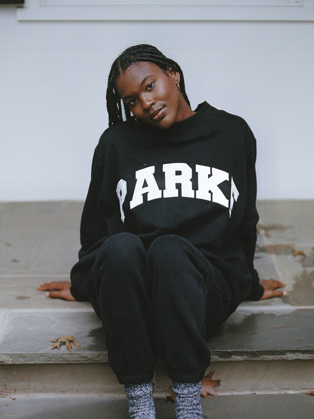 model wearing black varsity mockneck -black + white