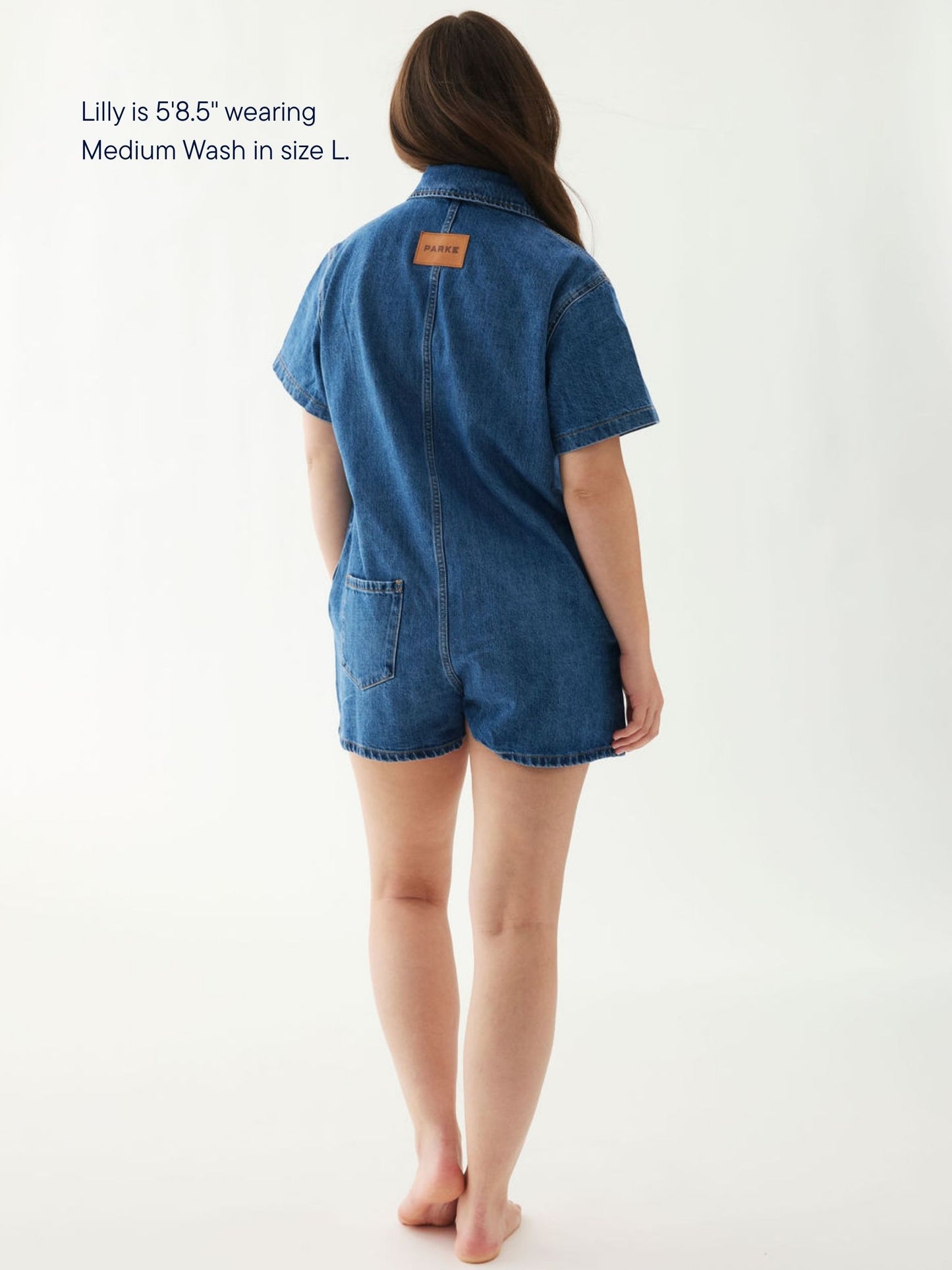girl wearing short sleeve denim romper -medium wash