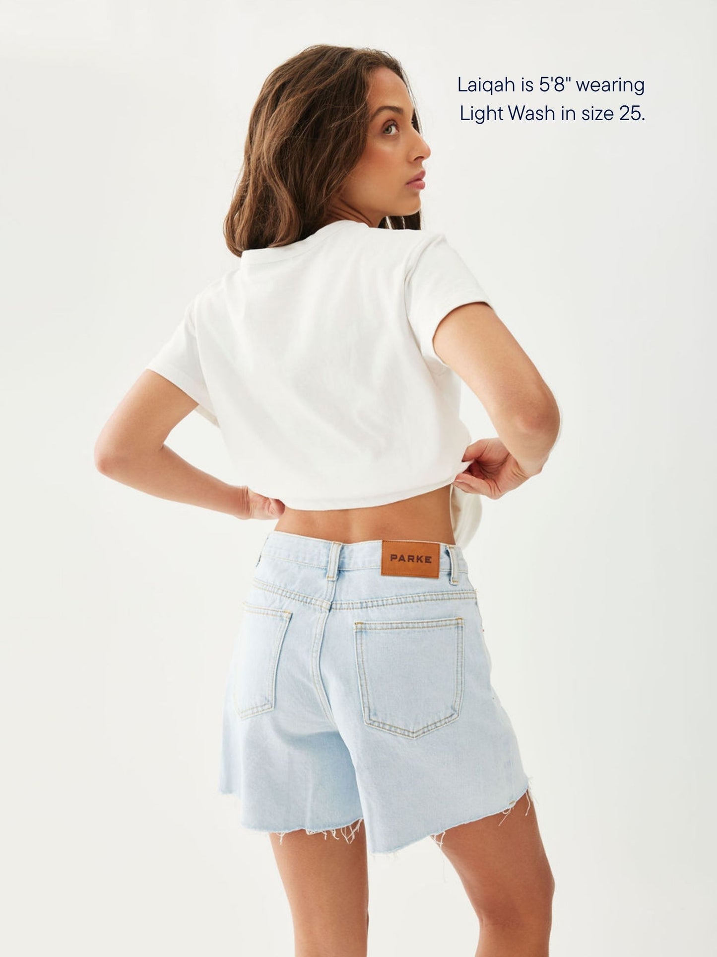 girl wearing long baggy shorts -light wash
