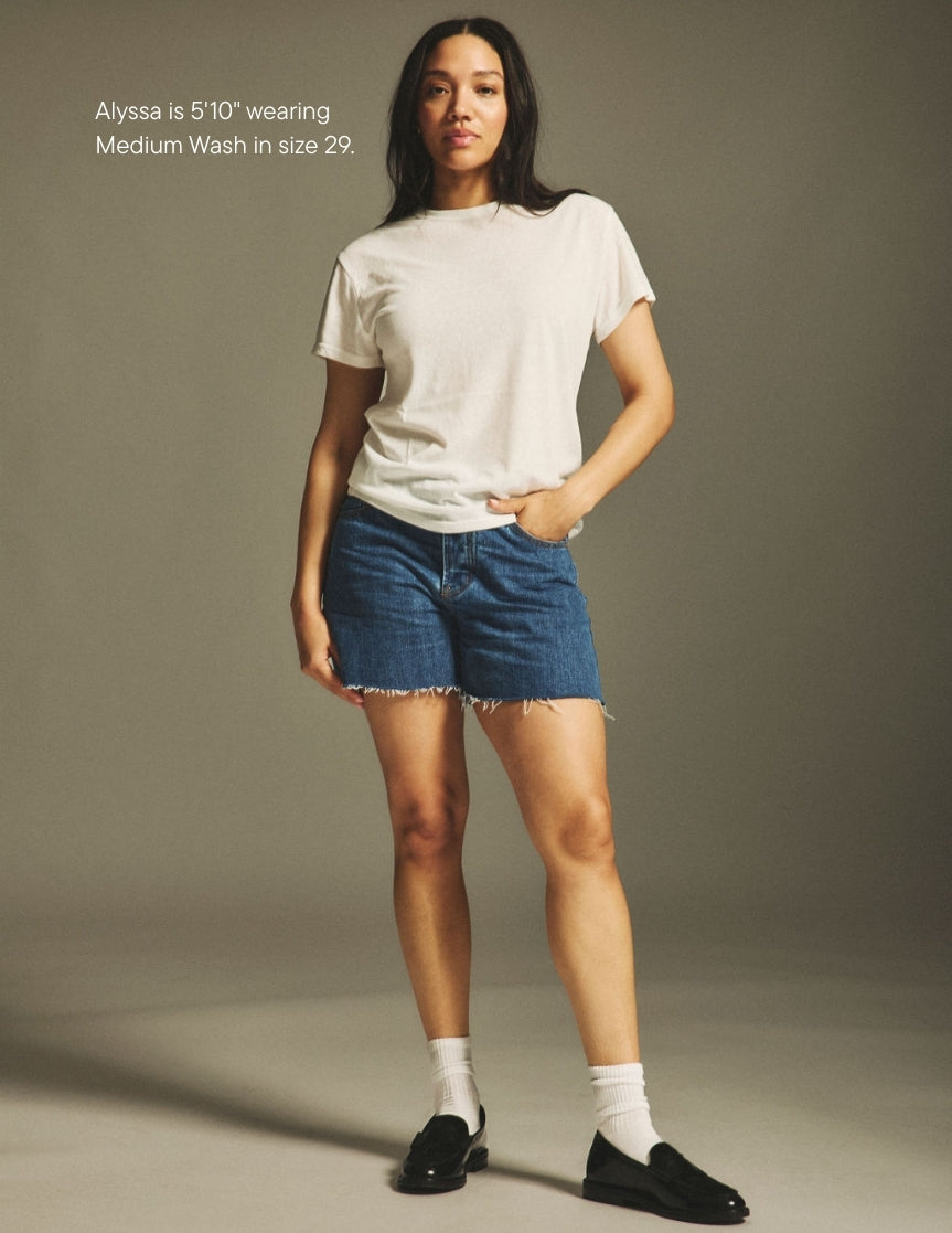 girl wearing long baggy shorts -medium wash