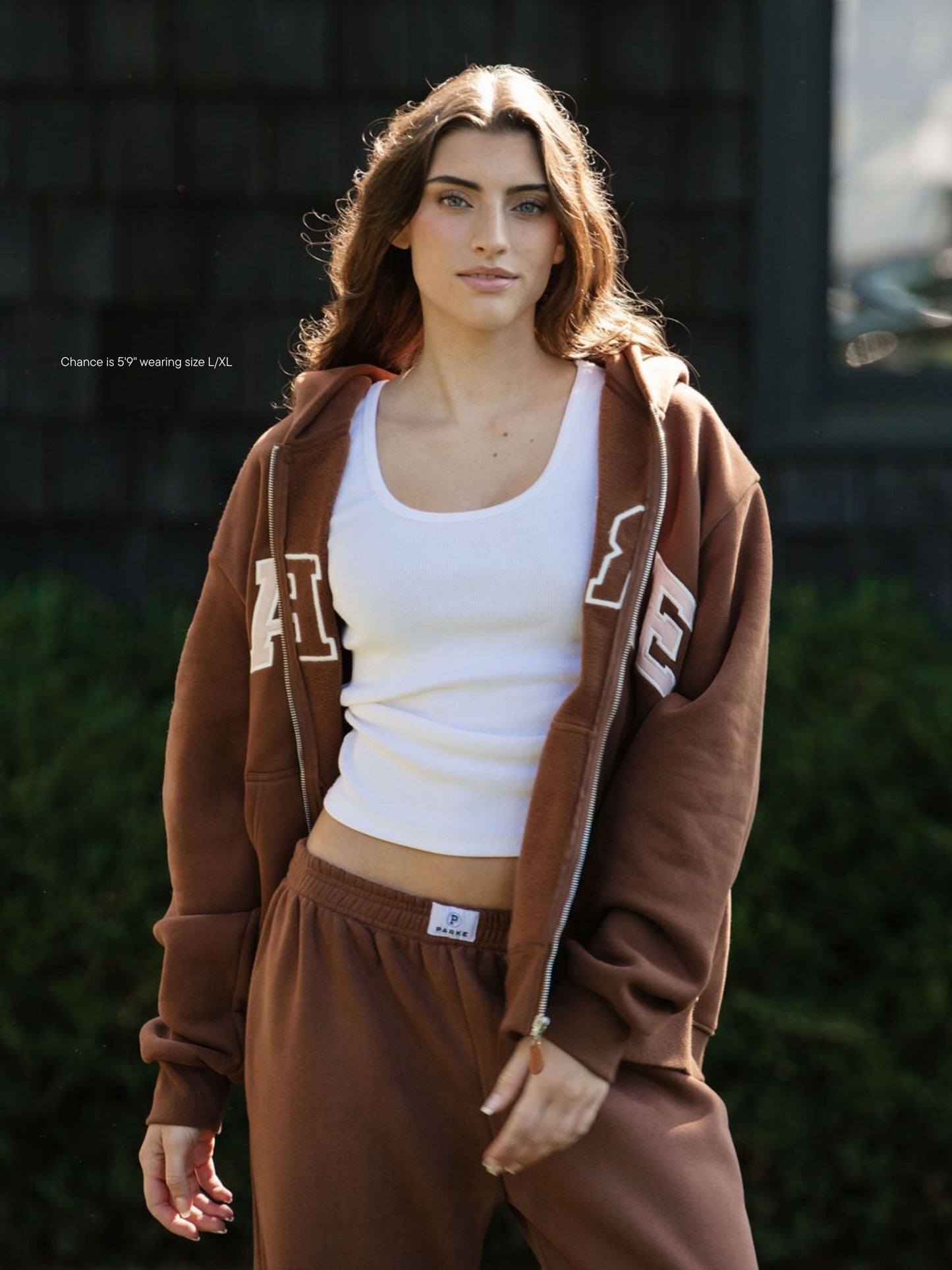 girl wearing varsity zip up hoodie -mocha + rose