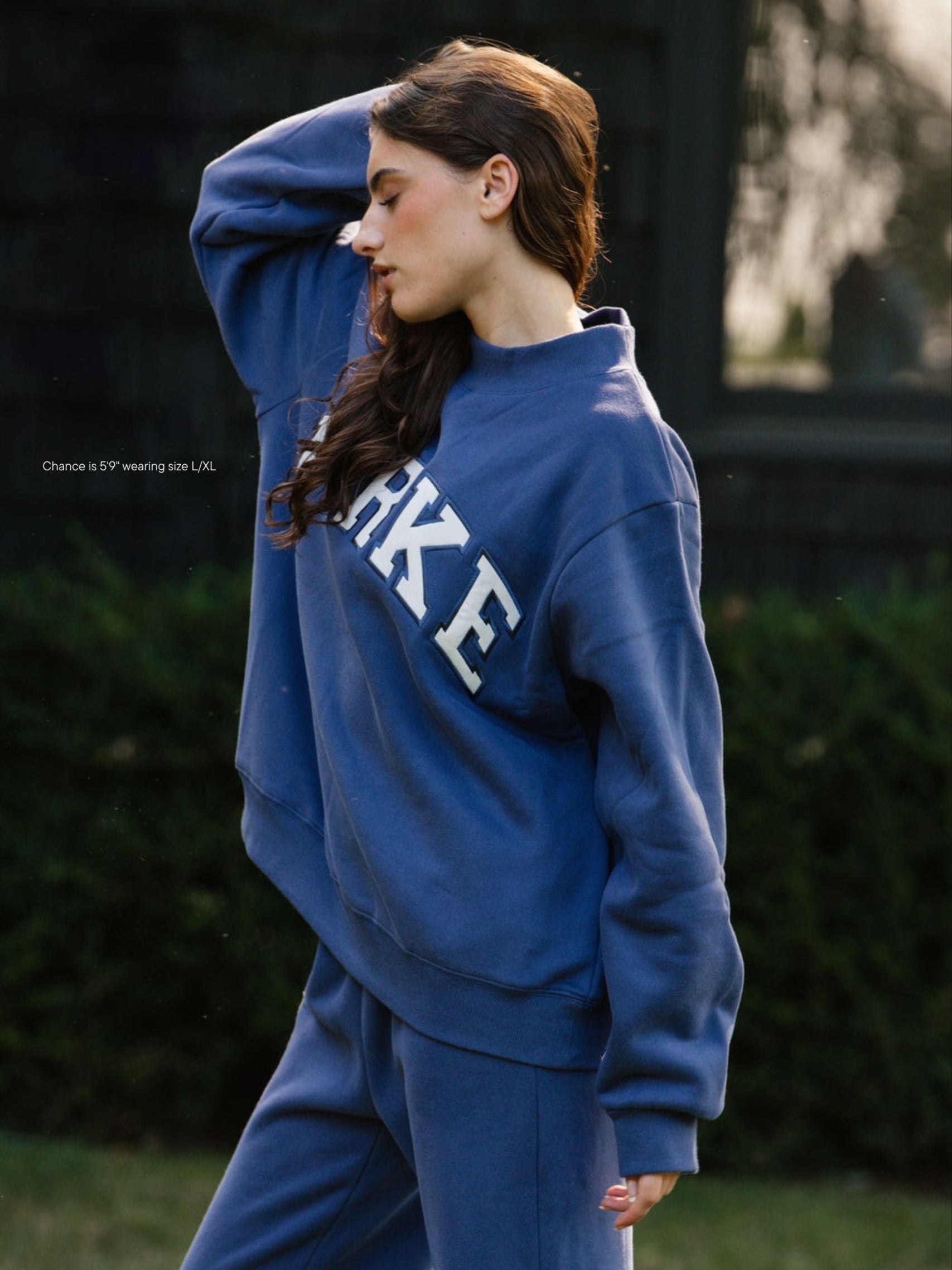 girl wearing hometown varsity mockneck flat -crown blue + white