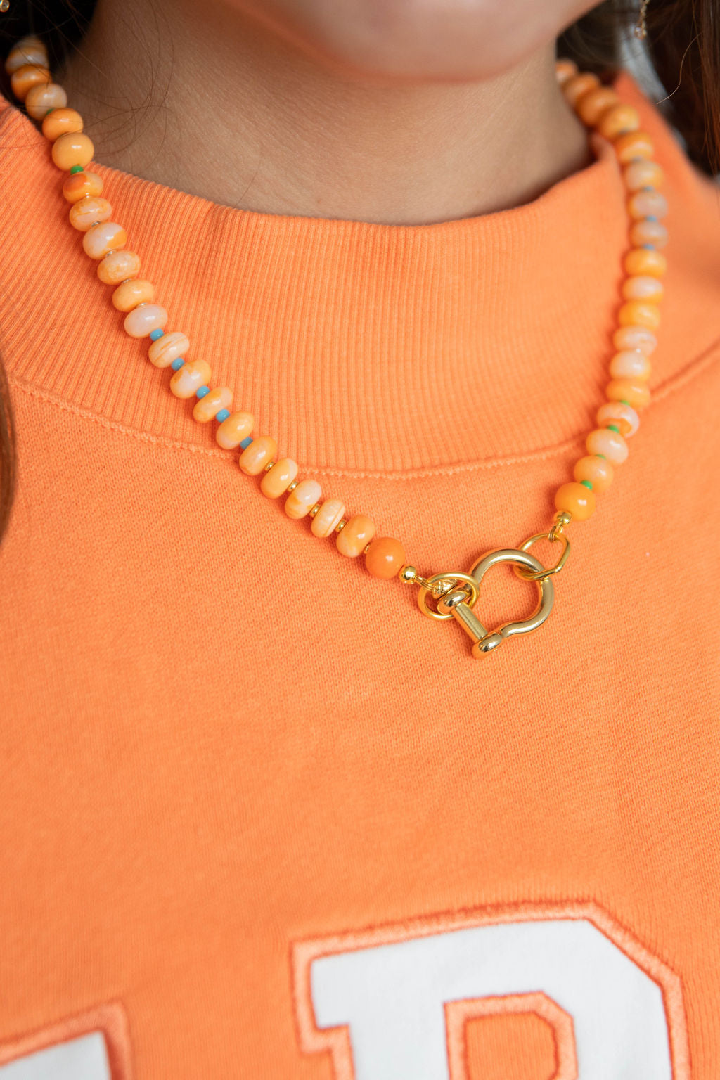 girl wearing spicy dan necklace -orange