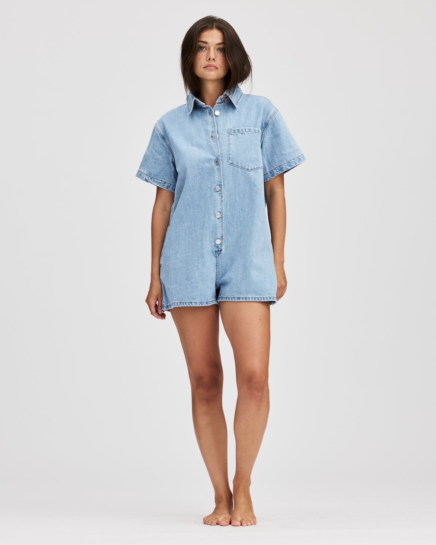 model wearing short sleeve denim romper -light wash