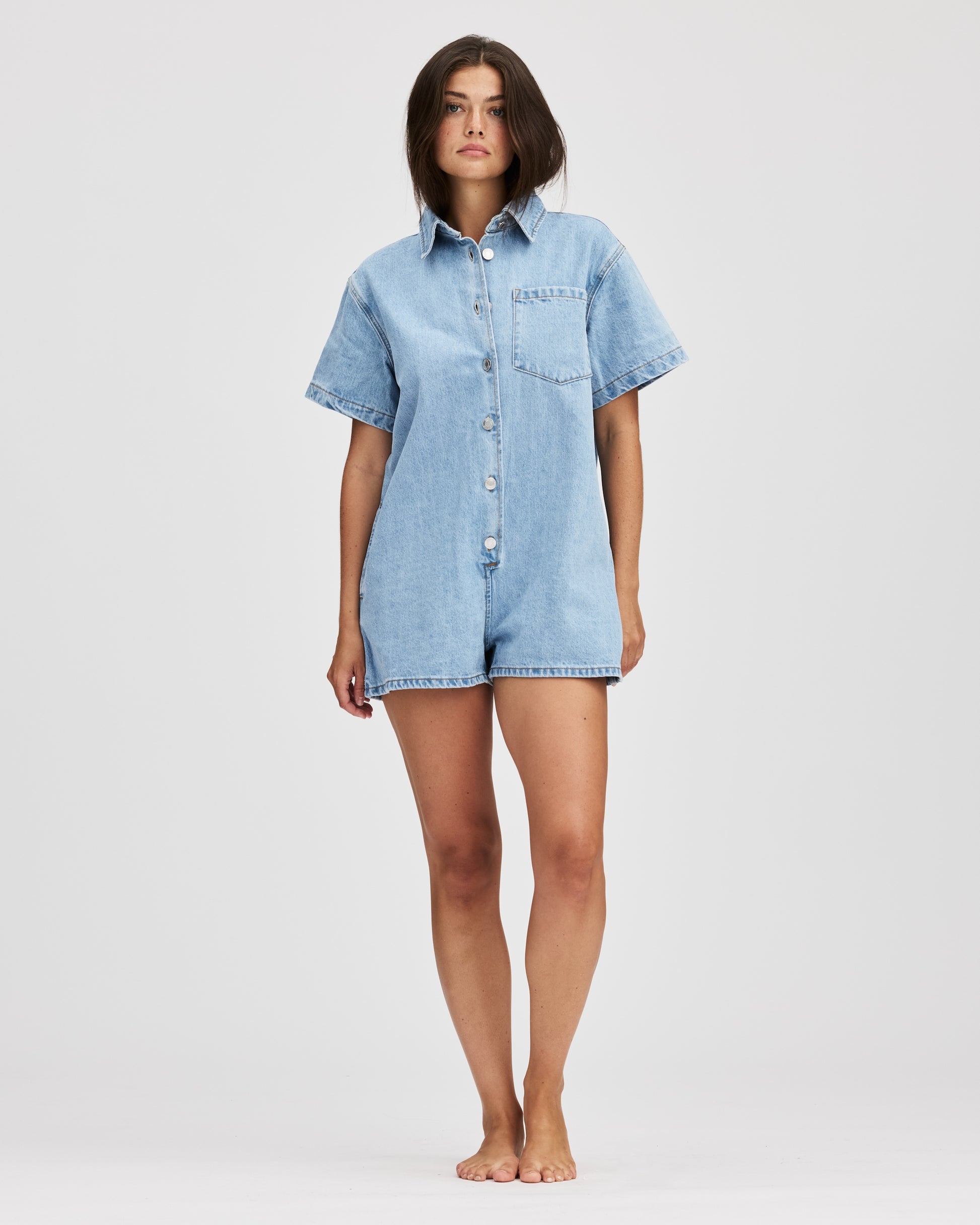 model wearing short sleeve denim romper -light wash