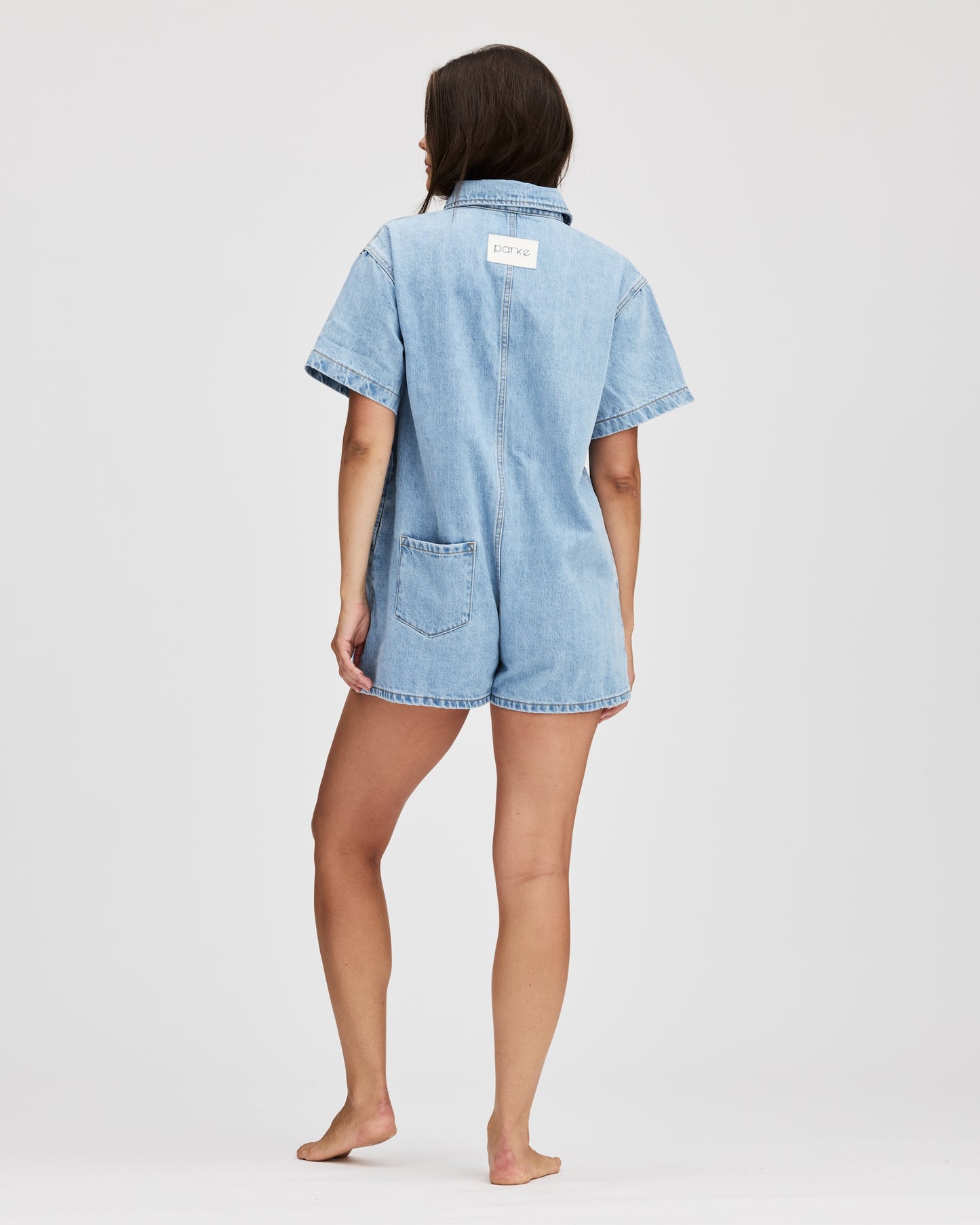 model wearing short sleeve denim romper -light wash