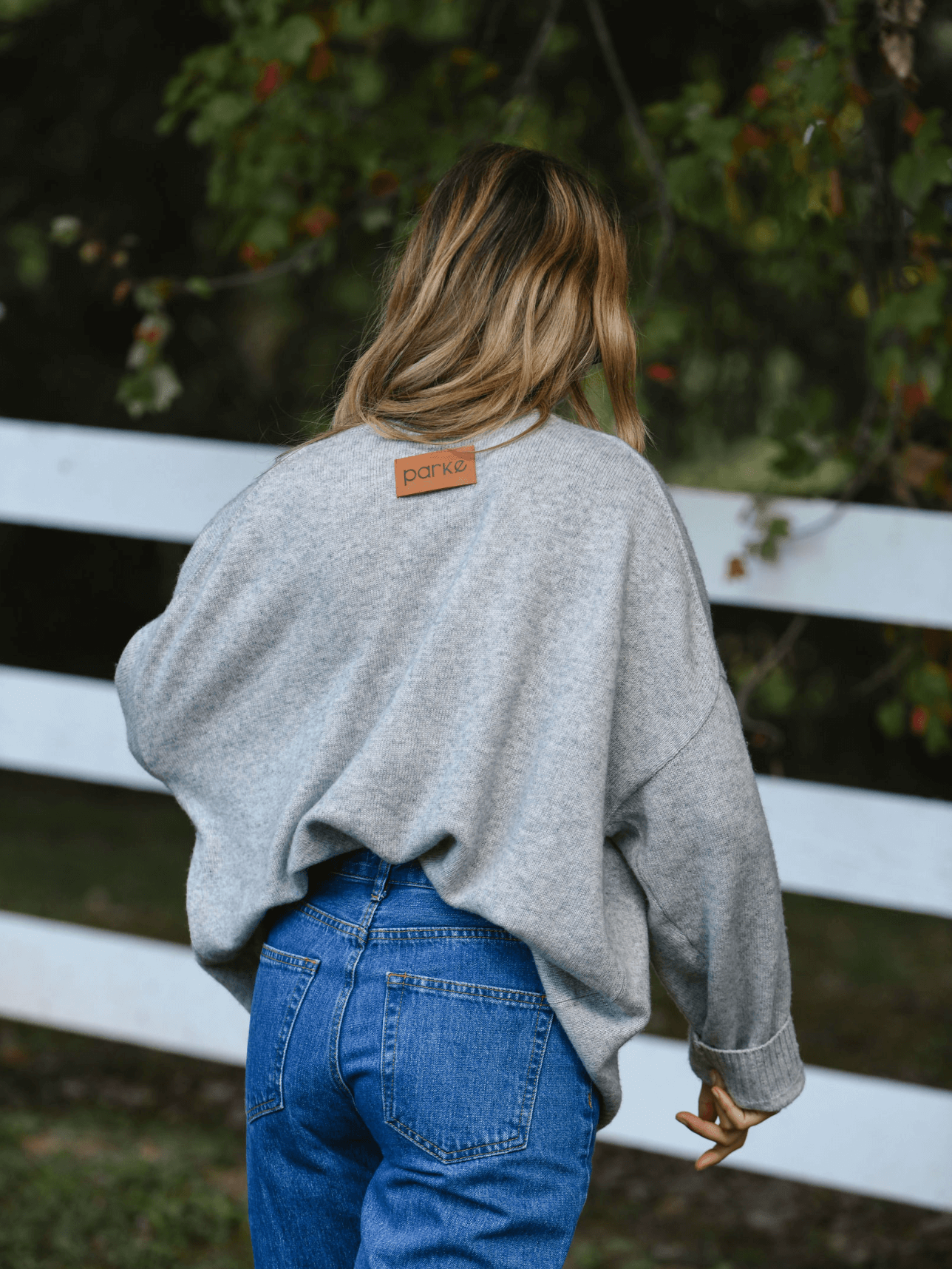 girl showing back patch of heather grey oversized pullover sweater -heather grey