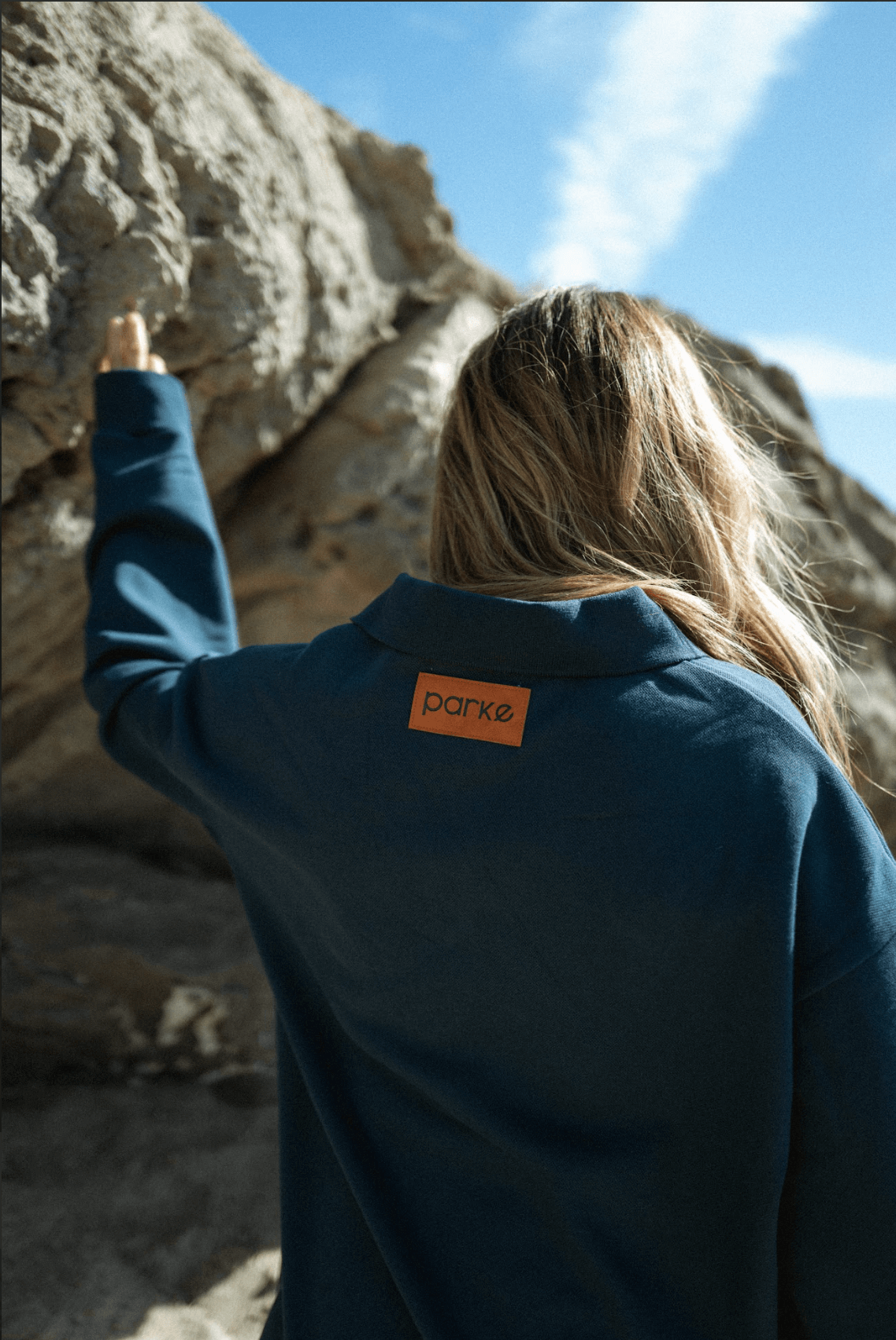 girl showing back patch of long sleeve polo - reef