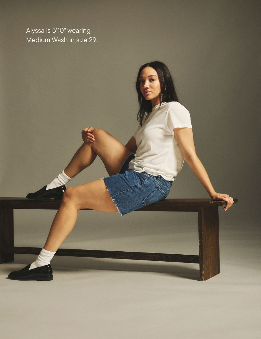 girl wearing long baggy shorts -medium wash