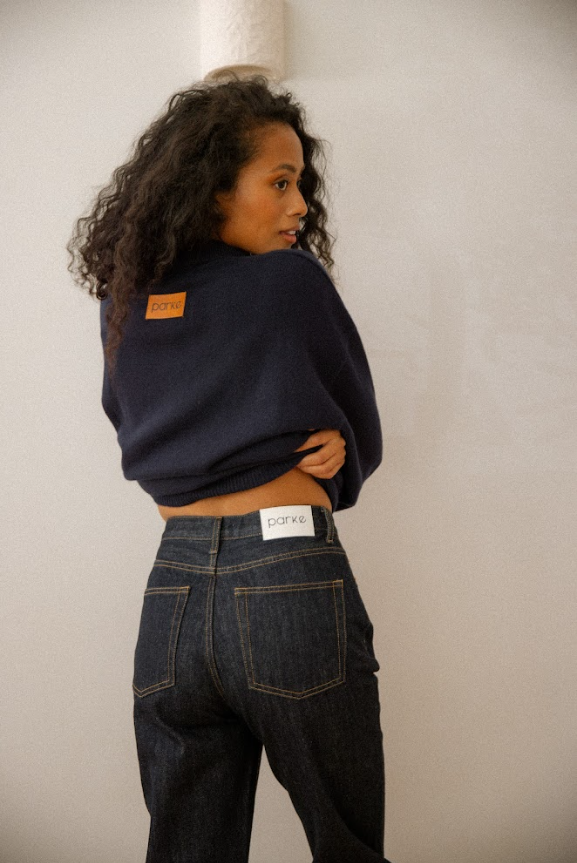 close up view of girl wearing dark wash 90s straight jeans showing the PARKE label on the back of the jean -dark wash