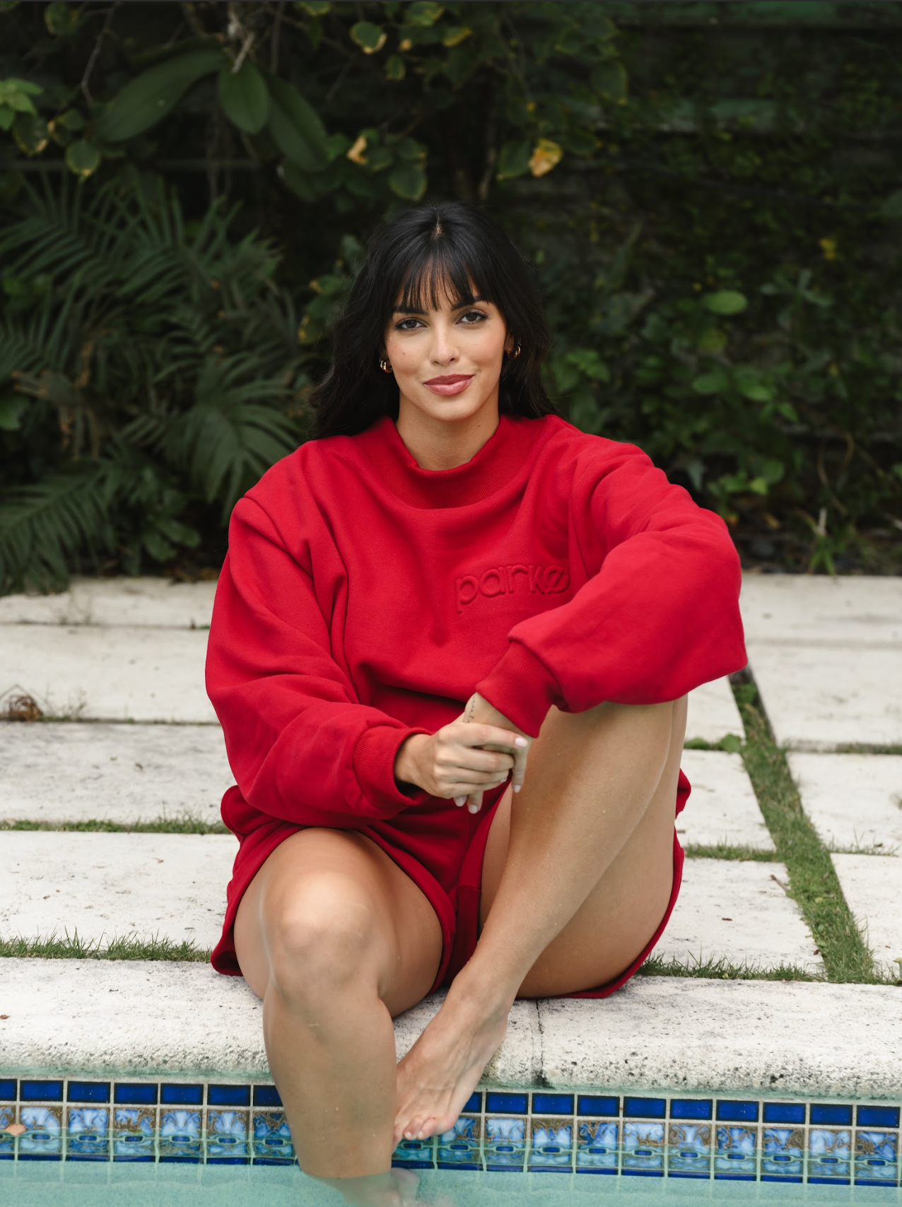 girl wearing maroon embossed mockneck sitting by pool- maroon