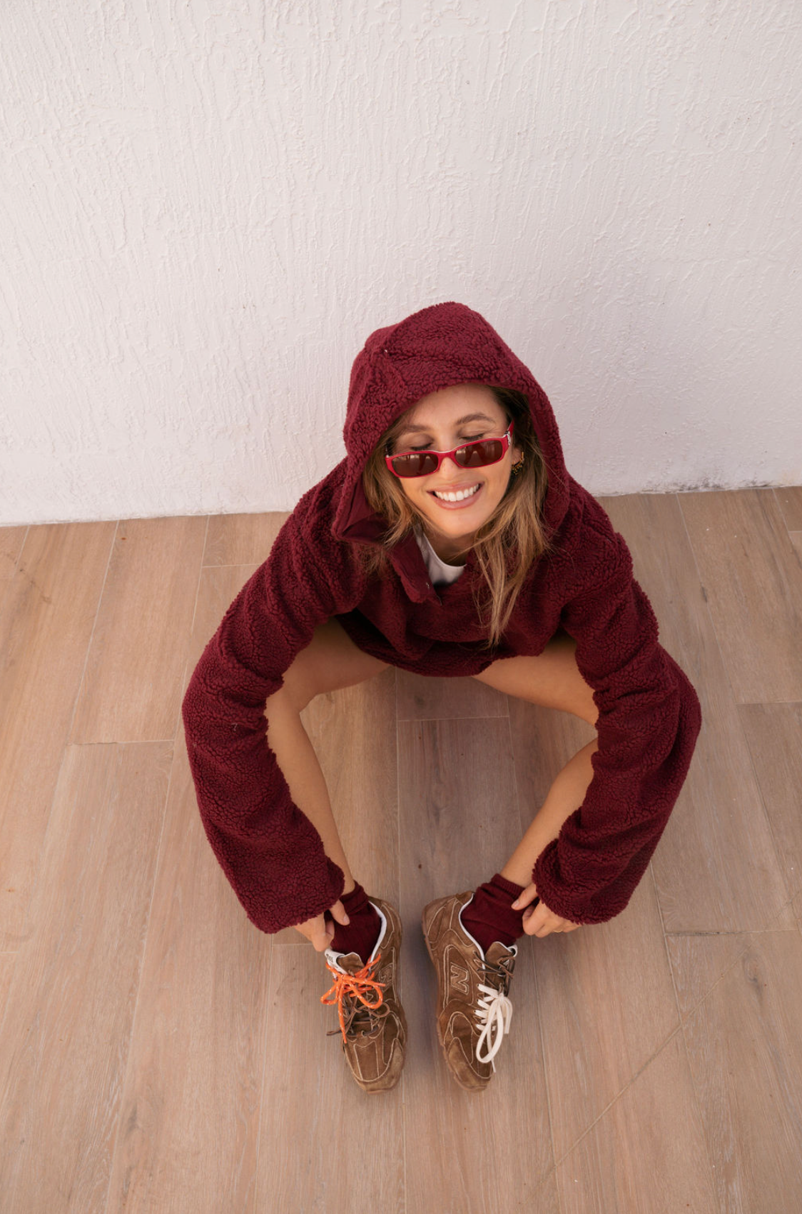 girl sitting wearing maroon hooded fleece- maroon