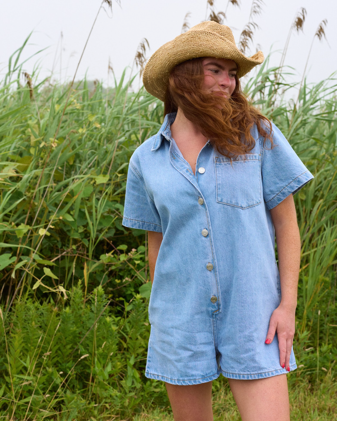 model wearing short sleeve denim romper - light wash