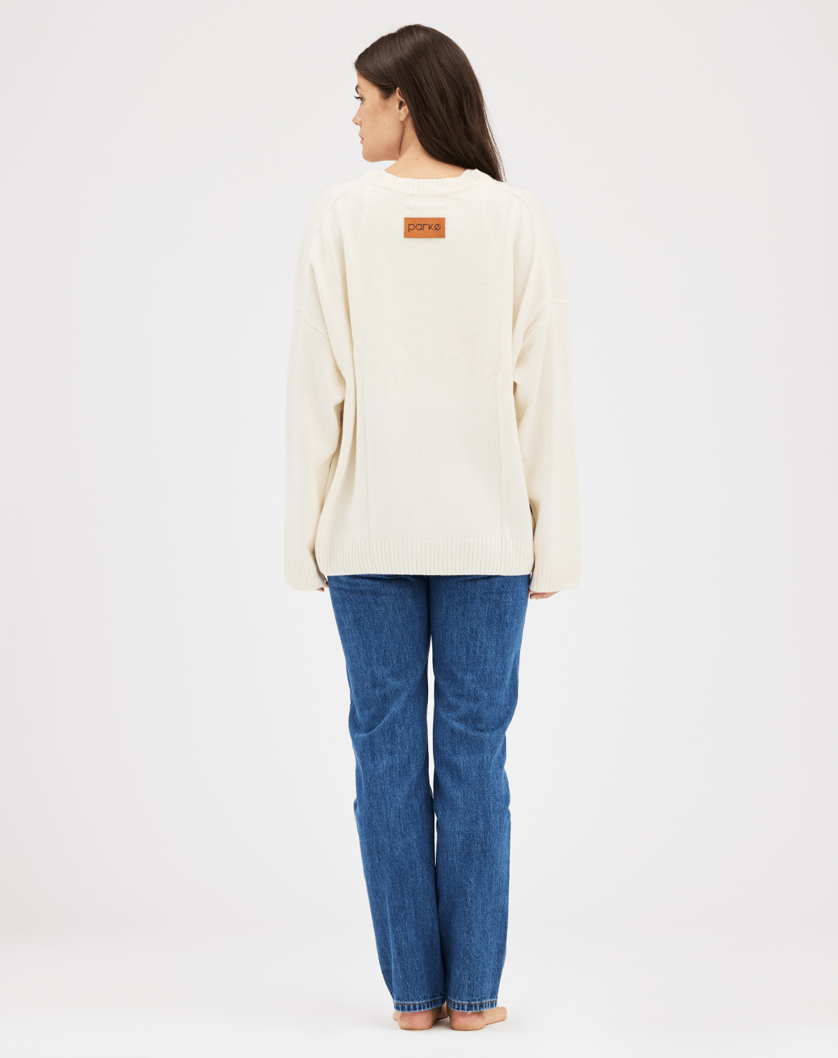 girl showing back patch of cream pull over sweater - cream