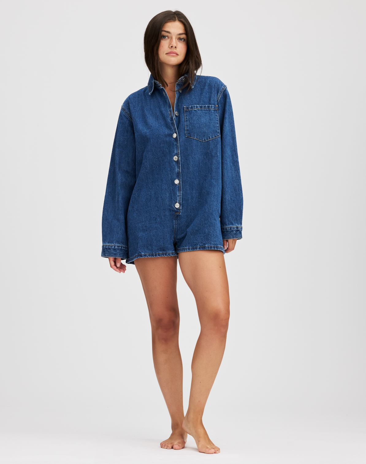 full body image of girl wearing the med wash long sleeve denim romper- med wash