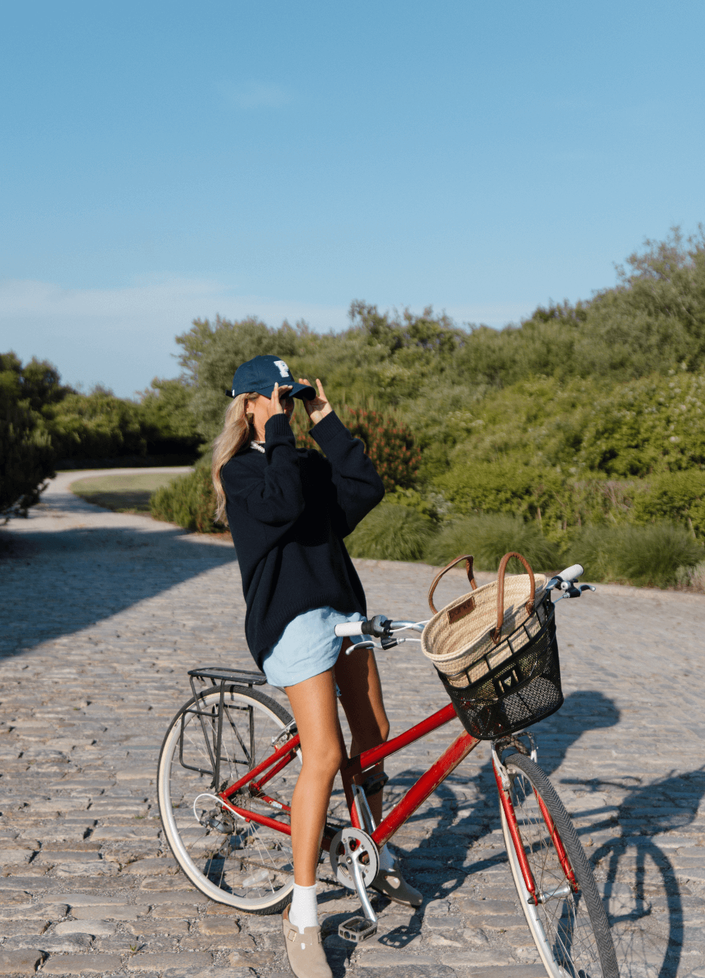 Girl riding bike wearing navy P baseball hat -Navy