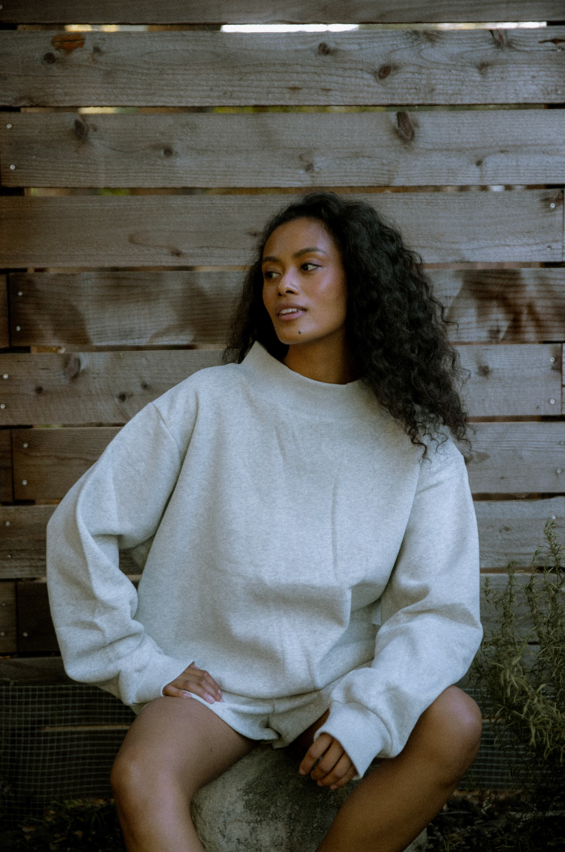 Model sitting wearing  grey classic mockneck- grey